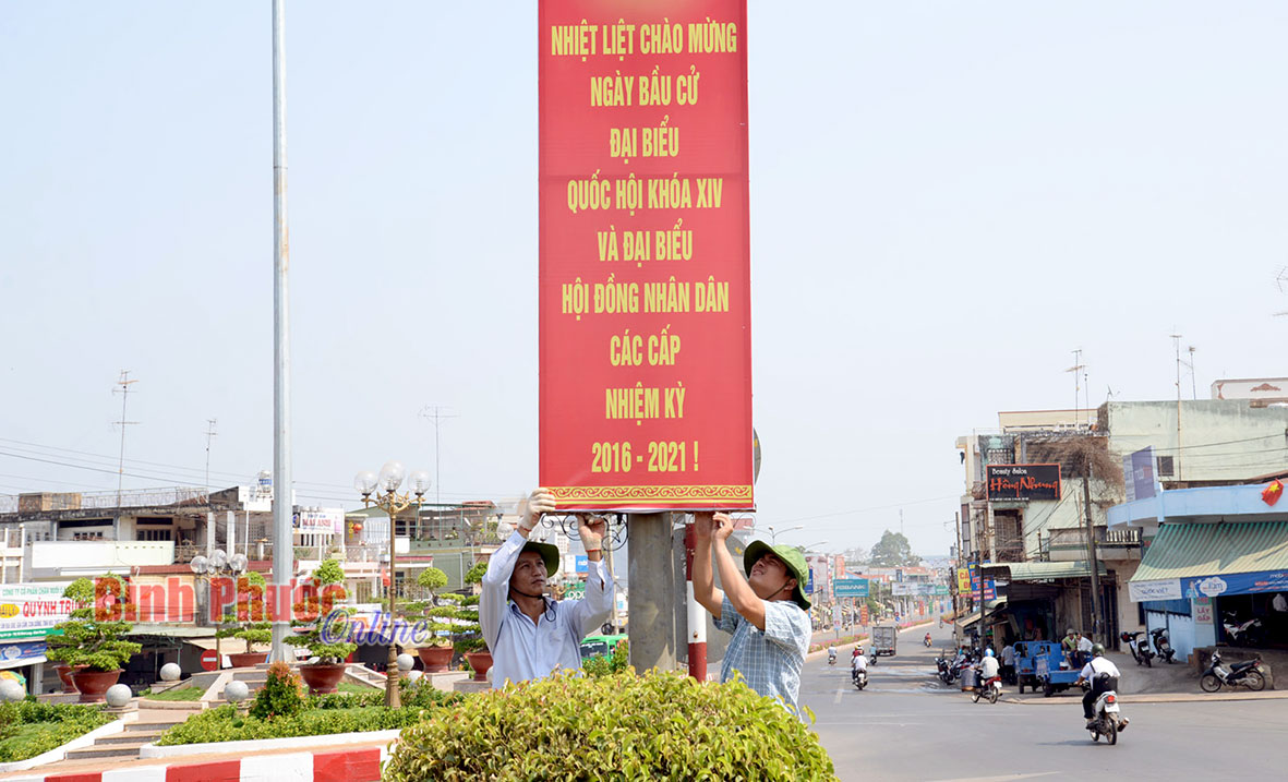 Đội tuyên truyền lưu động - Trung tâm Văn hóa - Thể thao thị xã Bình Long gắn pa-nô tuyên truyền bầu cử