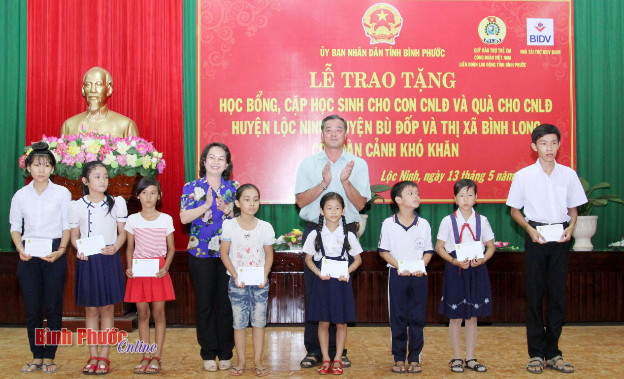 Bí thư Huyện ủy Lộc Ninh Trần Thị Ánh Tuyết, Chủ tịch LĐLĐ tỉnh Nguyễn Hồng Trà trao học bổng và quà của UBND tỉnh cho người lao động và con người lao động có hoàn cảnh khó khăn