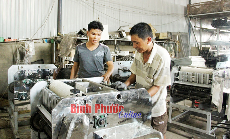 Anh Tiến (bên trái) giám sát công nhân tại xưởng chế tạo máy