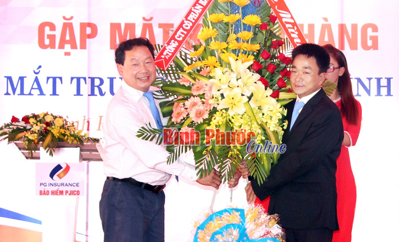 Ông Nguyễn An Hòa (trái), Phó tổng giám đốc Công ty PJCO tặng lẵng hoa chúc mừng ngày ra mắt trụ sở PJICO Bình Phước