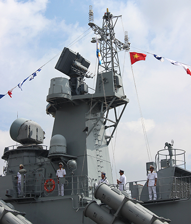 Chính trị viên tàu HQ377 Trần Ngọc Quỳnh đang thực hiện nghi thức treo quốc kỳ và hải kỳ trên cabin thượng tầng của tàu HQ377 