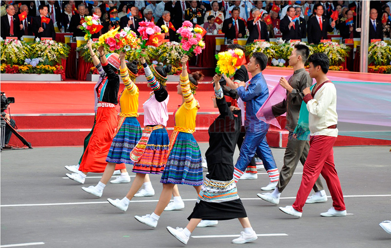 Đại diện c&aacute;c d&acirc;n tộc diễu h&agrave;nh trong cờ hoa ch&uacute;c mừng của l&atilde;nh đạo Đảng, Nh&agrave; nước