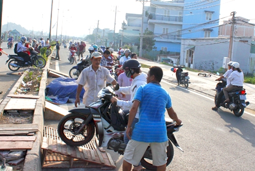 Nhiều người đã kê bục gỗ để xe máy leo qua dải phân cách. (Ảnh Hữu Công) 