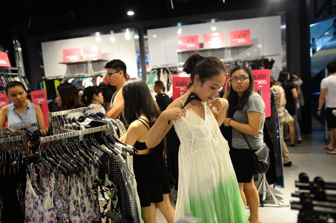 Khách hàng chọn mua quần áo của các thương hiệu nước ngoài tại trung tâm thương mại Q.1, TP.HCM - Ảnh: Thuận Thắng