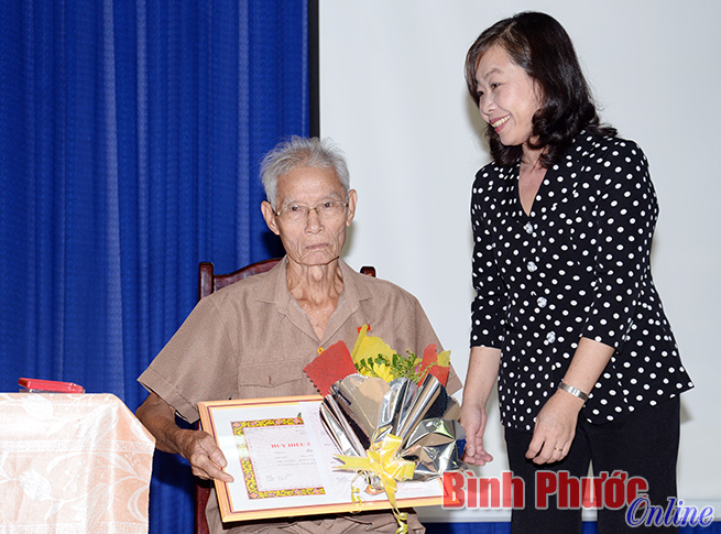 Đảng viên lão thành Quách Văn Ánh nhận hoa chúc mừng và Huy hiệu 55 tuổi đảng