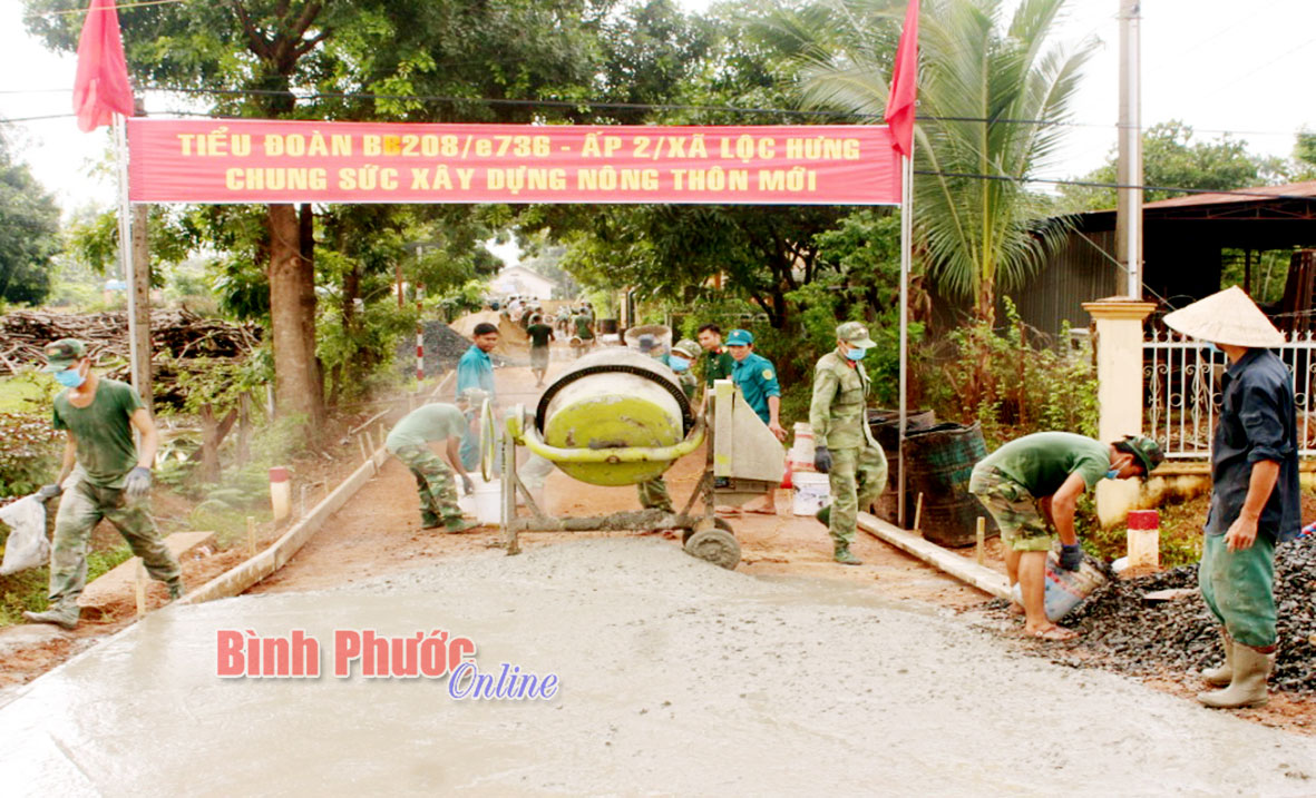 Cán bộ, chiến sĩ Tiểu đoàn 208 cùng nhân dân ấp 2, xã Lộc Hưng đổ bê tông đường giao thông nông thôn