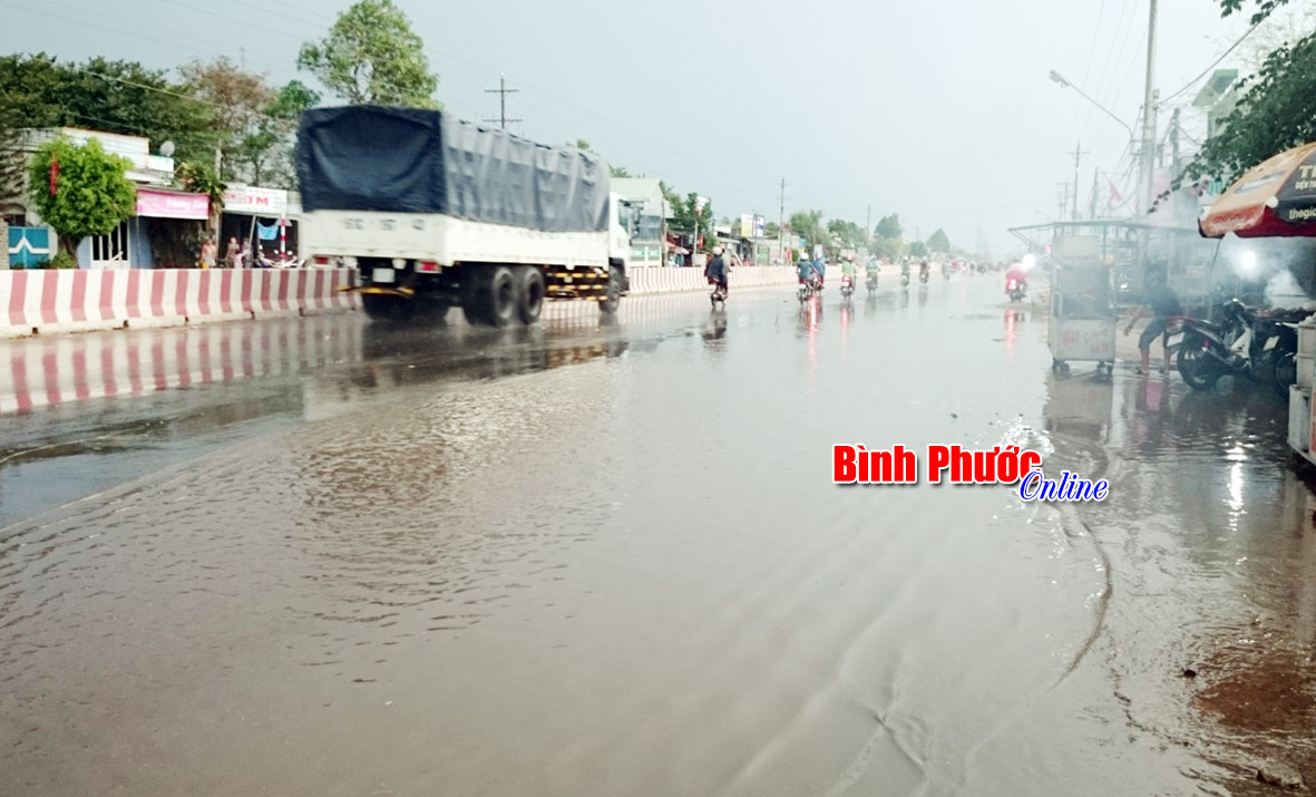 Quốc lộ 13, đoạn gần cổng KCN Minh Hưng III nước ngập quá nửa mặt đường