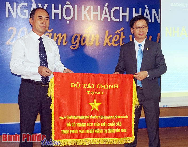 Thừa ủy quyền của Bộ trưởng Bộ T&agrave;i ch&iacute;nh, Ph&oacute; chủ tịch UBND tỉnh Nguyễn Tiến Dũng trao cờ thi đua cho l&atilde;nh đạo Bảo Việt nh&acirc;n thọ B&igrave;nh Phước