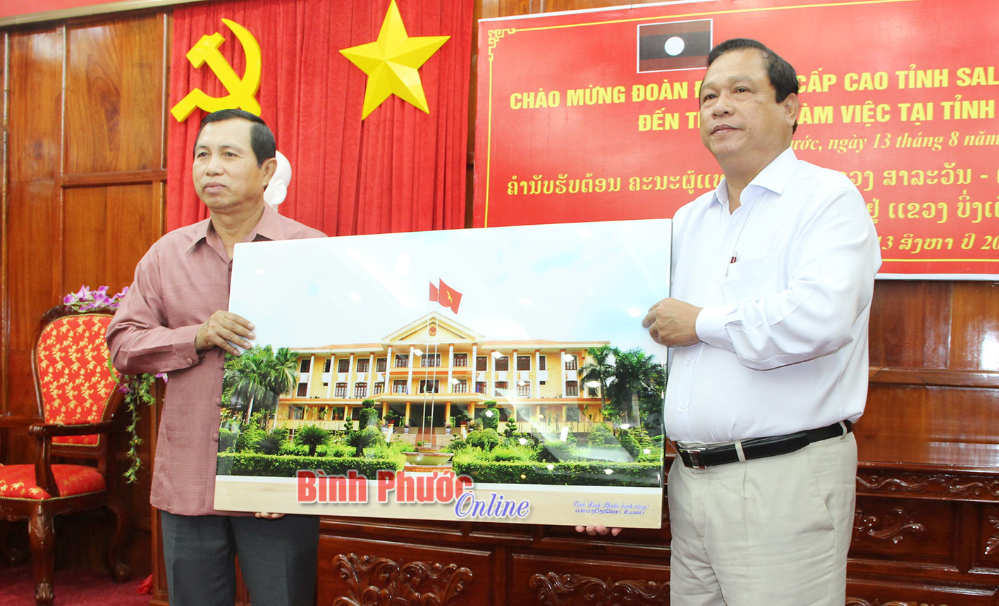 Đồng chí Nguyễn Văn Trăm, Phó bí thư Tỉnh ủy, Chủ tịch UBND tỉnh Bình Phước tặng quà lưu niệm cho tỉnh Salavan