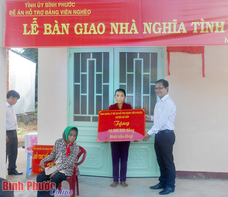 B&iacute; thư Huyện ủy H&agrave; Anh Dũng trao số tiền hỗ trợ của Ban quản l&yacute; đề &aacute;n huyện B&ugrave; Đốp cho đại diện gia đ&igrave;nh đảng vi&ecirc;n Trần Thị B&ecirc;