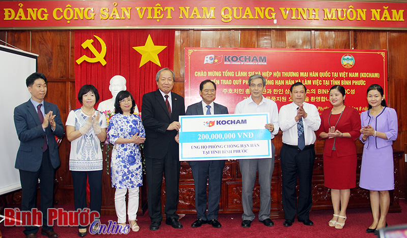 Tổng l&atilde;nh sự Park Noh Wan v&agrave; Chủ tịch Hiệp hội thương nghiệp v&agrave; c&ocirc;ng nghiệp Han Dong Hee trao quỹ hạn h&aacute;n cho tỉnh B&igrave;nh Phước