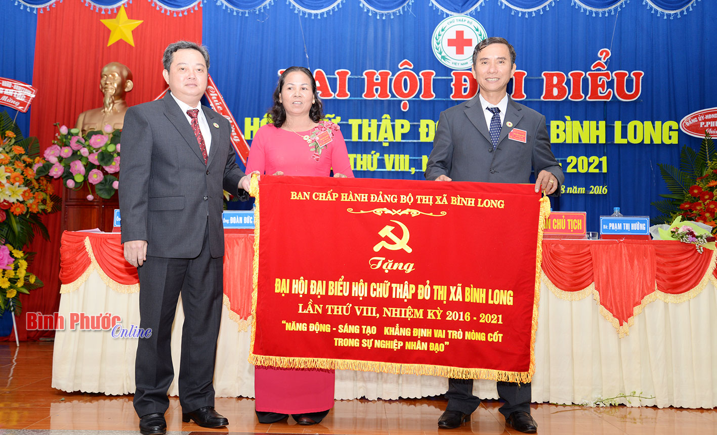 Bí thư Thị ủy Bình Long Nguyễn Minh Hợi trao tặng bức trướng của Đảng bộ thị xã cho đại hội 