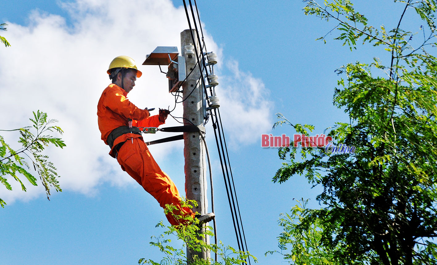 Công nhân kết nối điện lưới quốc gia vào nhà dân ở tổ 3, ấp 9, xã Thanh Hòa (Bù Đốp)