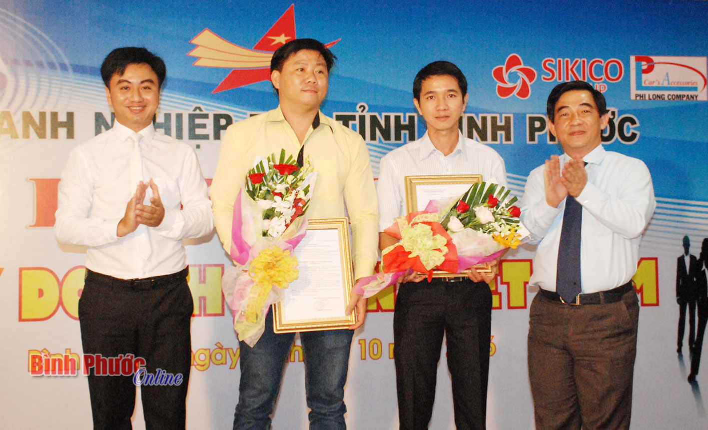 Chủ tịch và Phó chủ tịch Hội doanh nghiệp trẻ tỉnh Bình Phước tặng hoa cho hai thành viên mới 