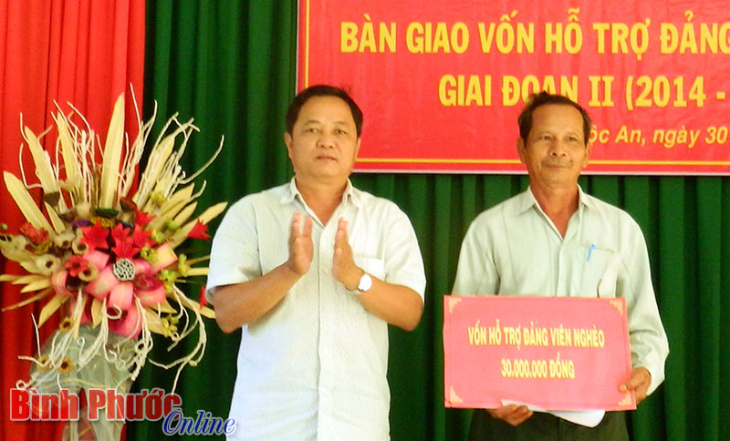 Ph&oacute; b&iacute; thư thường trực Huyện ủy Lộc Ninh Nguyễn Tiến Cường trao bảng tượng trưng hỗ trợ vốn cho đảng vi&ecirc;n Điểu Đức