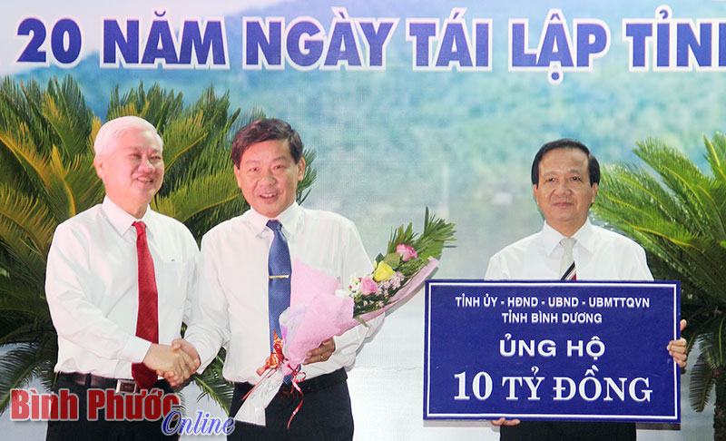 Chủ tịch UBND tỉnh Bình Dương Trần Thanh Liêm trao biểu trưng 10 tỷ đồng ủng hộ người nghèo Bình Phước - Ảnh: V. Thuyên