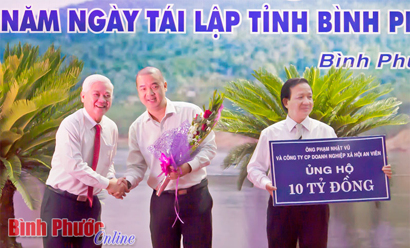 Ông Phạm Nhật Vũ, Công ty cổ phần doanh nghiệp xã hội An Viên trao biểu trưng 10 tỷ đồng ủng hộ người nghèo Bình Phước - Ảnh: S. Hòa