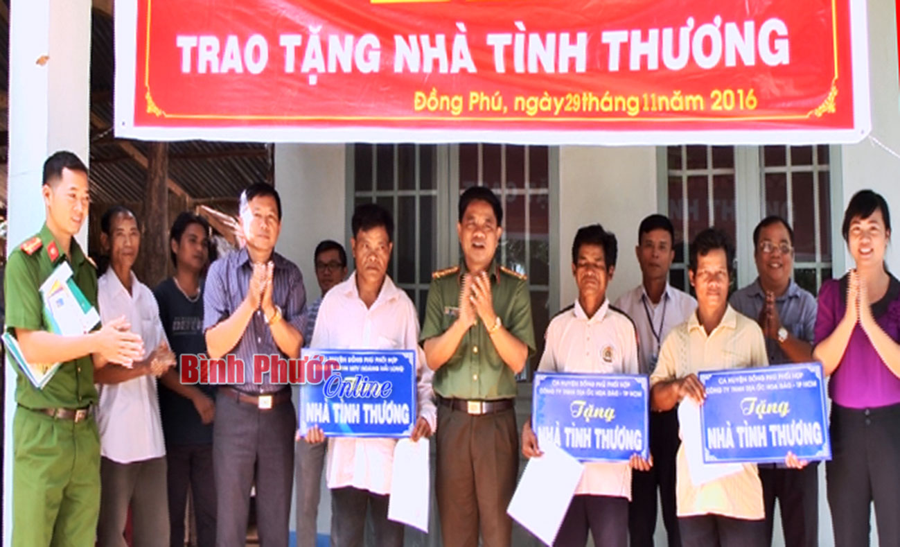 Đại tá Trần Việt Anh, Trưởng công an huyện Đồng Phú và đại diện Công ty TNHH địa ốc Hoa Đào trao quyết định tặng nhà cho các hộ nghèo