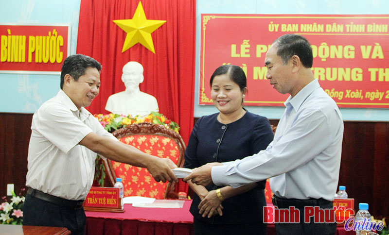 Đại diện UBMTTQVN tỉnh (bên trái) nhận tiền quyên góp ủng hộ sau lễ phát động ngày 25-10-2016