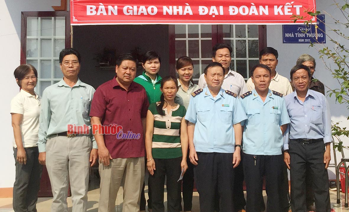 Lãnh đạo Cục Hải quan tỉnh Bình Phước cùng chính quyền địa phương chụp hình lưu niệm với gia đình bà Doán tại lễ trao tặng căn nhà đại đoàn kết