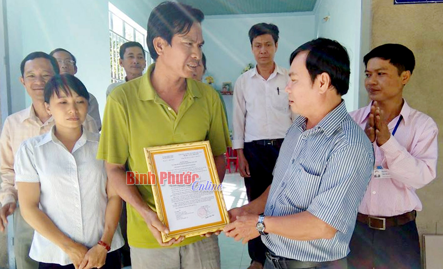 Ông Nguyễn Thành Hạnh, Phó chủ tịch UBMTTQVN huyện Đồng Phú trao quyết định cho gia đình ông Lê Ích Tuấn