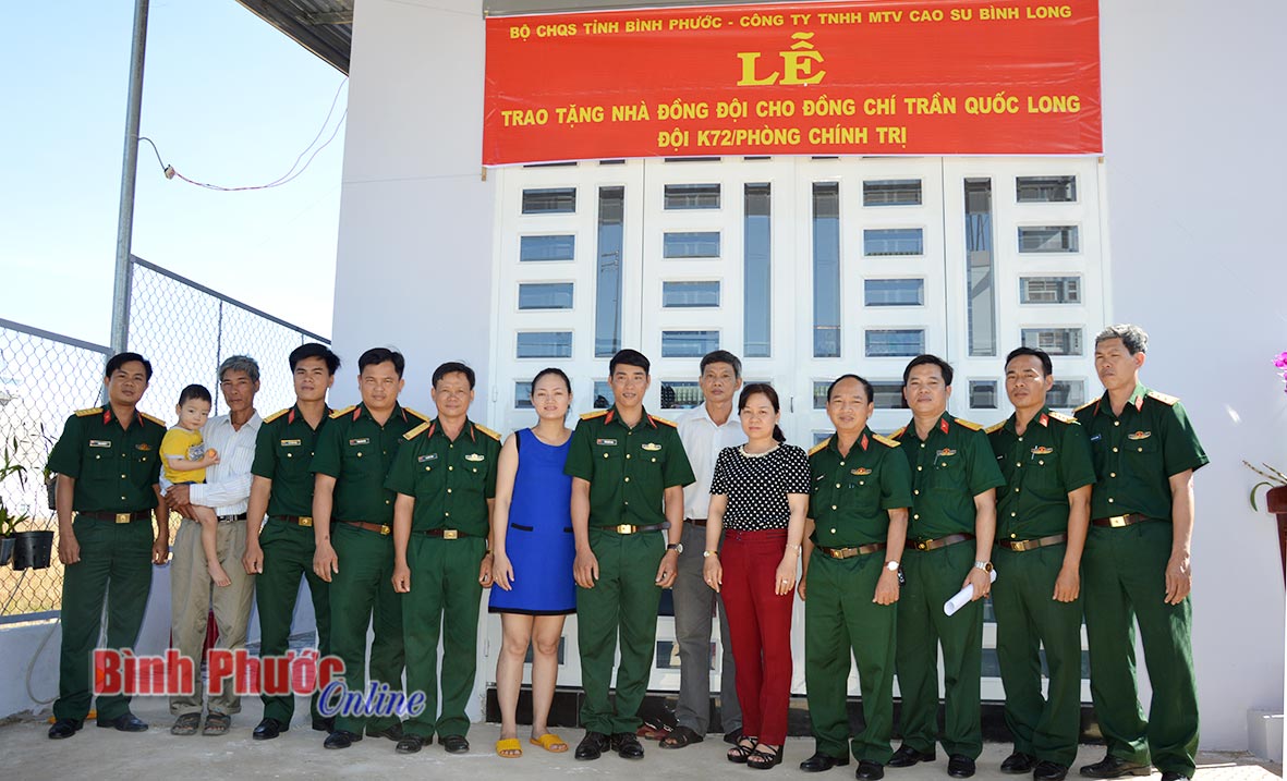 Đại diện lãnh đạo Bộ CHQS tỉnh, chính quyền địa phương chụp hình lưu niệm cùng gia đình Trung úy Trần Quốc Long