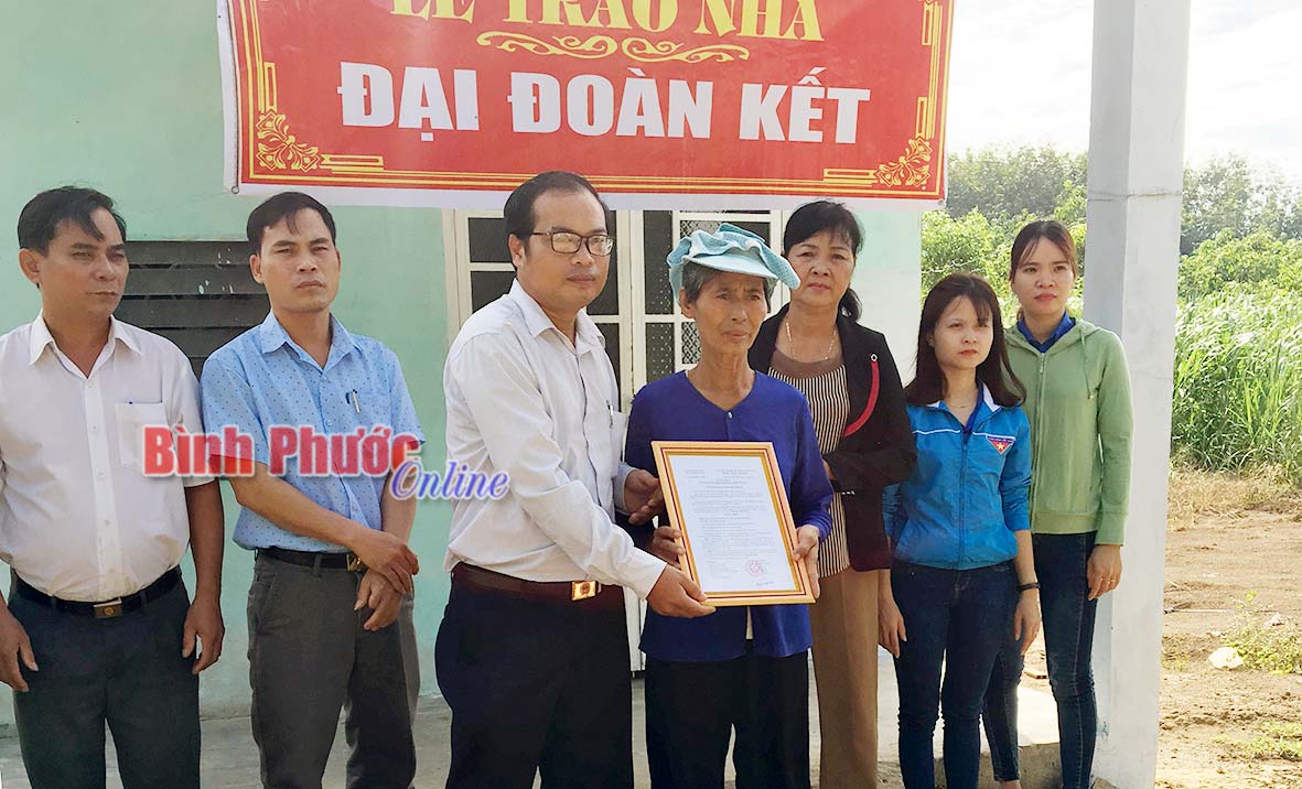 Đại diện Ban Thường trực UBMTTQVN huyện Đồng Phú trao quyết định bàn giao nhà cho hộ bà Nguyễn Thị Tâm