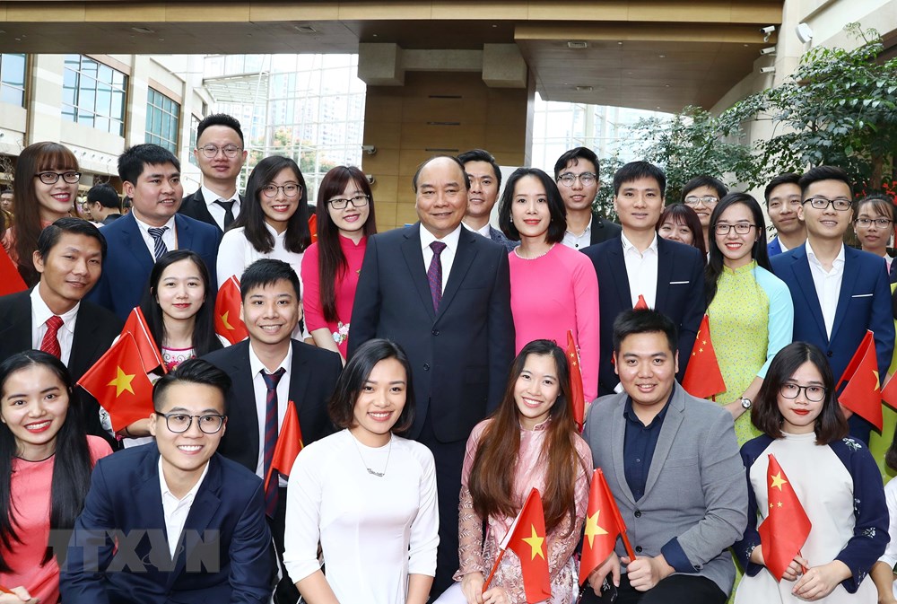 Thủ tướng chụp ảnh chung với kiều bào Việt Nam tại lễ đón. (Ảnh: Thống Nhất/TTXVN)