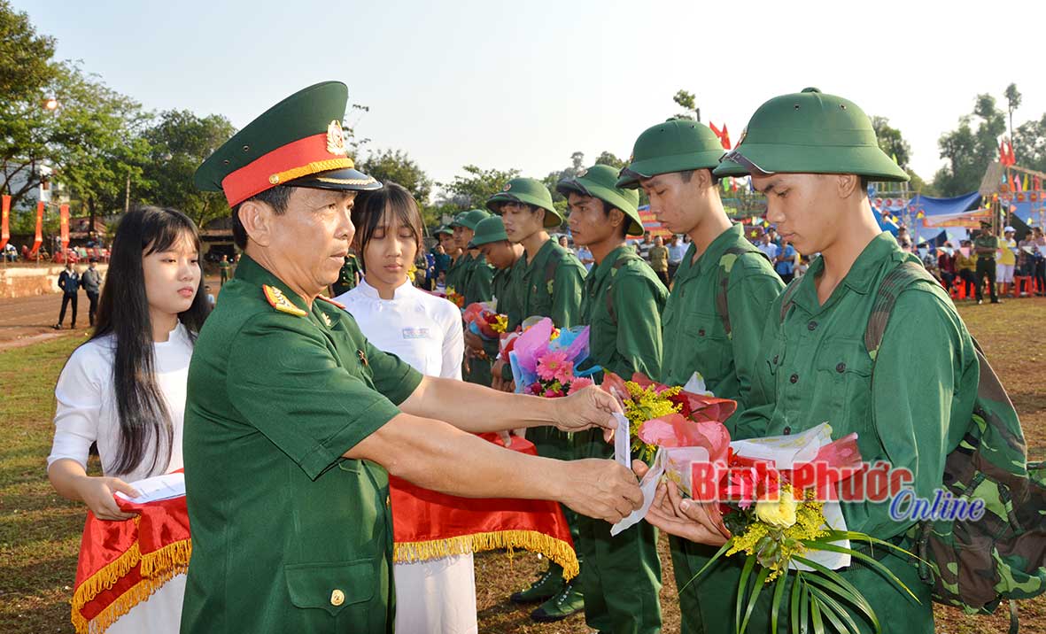 Đại tá Nguyễn Quốc Bình, Ủy viên Ban Thường vụ Tỉnh ủy, Chỉ huy trưởng Bộ CHQS tỉnh tặng hoa chúc mừng thanh niên lên đường nhập ngũ - Ảnh: Quang Thạch