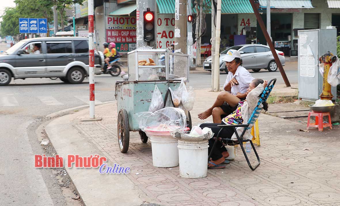 Dưới cái nắng như lửa đốt mùa khô, ở góc đường Trường Chinh - quốc lộ 14, phường Tân Phú vẫn có một cụ ông và một cụ bà thường xuyên ngồi bán bánh rán để mưu sinh.