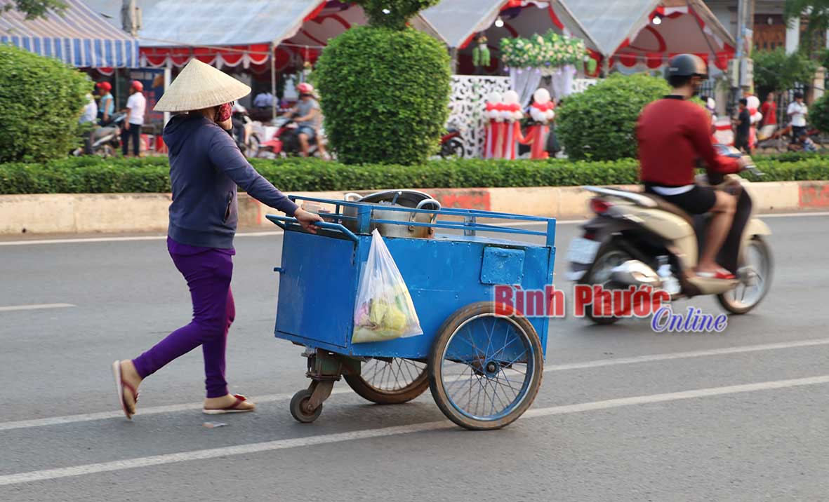 Chiếc xe chở cháo cá - đặc sản xứ Huế, được người phụ nữ trú tại phường Tân Phú đẩy đi bán dạo.