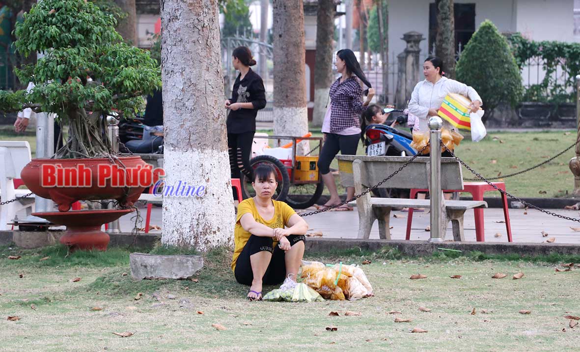 Người phụ nữ bán các loại trái cây gọt sẵn, bánh tráng trộn và nhiều thức ăn vặt khác... nghỉ ngơi sau một hồi cuốc bộ mệt mỏi.