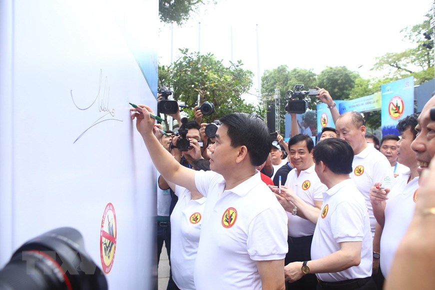  Phó Thủ tướng Thường trực Chính phủ Trương Hòa Bình gắn lôgô kêu gọi người tham gia giao thông Đã uống rượu bia-không lái xe cho đại biểu tham dự lễ phát động. (Ảnh: Minh Quyết/TTXVN)   Chủ tịch Ủy ban Nhân dân thành phố Hà Nội Nguyễn Đức Chung ký cam kết Đã uống rượu bia-không lái xe tại chương trình. (Ảnh: Minh Quyết/TTXVN)