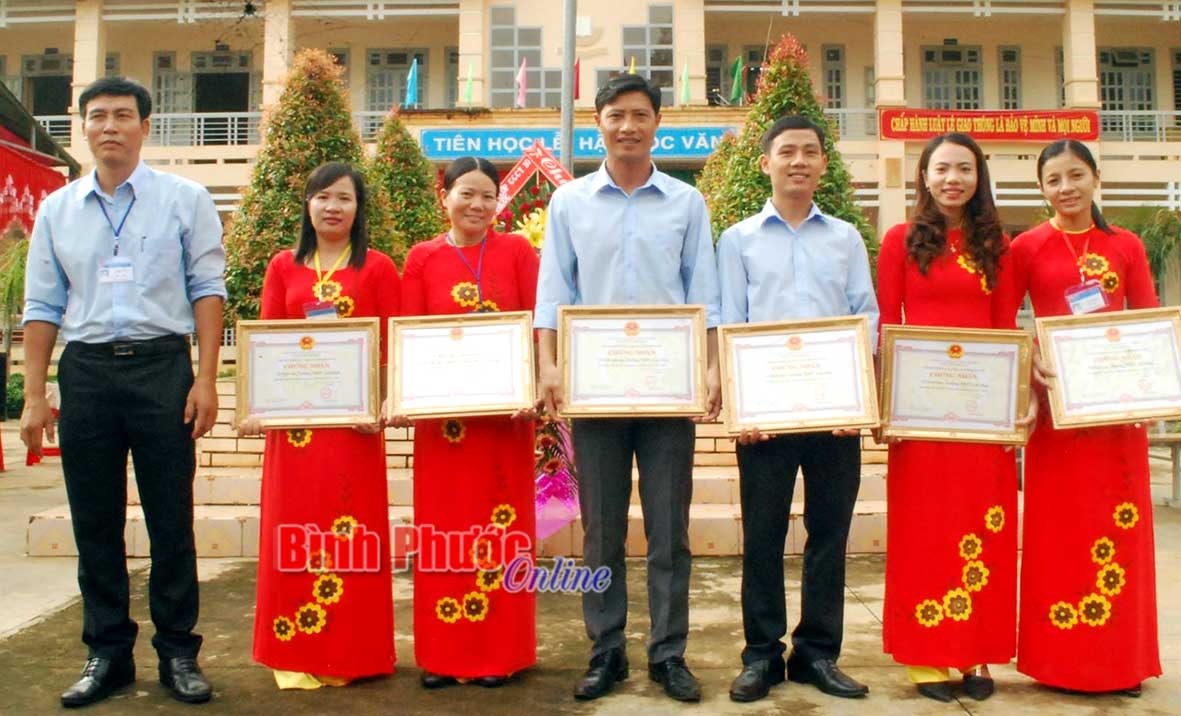 Thầy Vi Hữu Tài (ngoài cùng bên trái) trao giấy khen cho giáo viên đạt thành tích cao