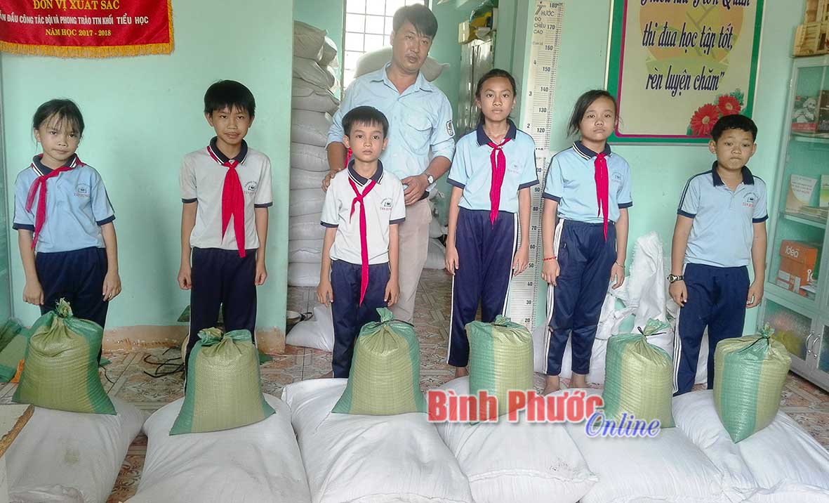 Học sinh ở ấp Sóc Quả, Trường tiểu học Tân Hưng A nhận gạo hỗ trợ