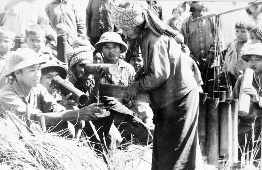  Người dân Campuchia mang nước thốt nốt đến cho bộ đội tình nguyện Việt Nam trong những ngày giúp dân Campuchia thu hoạch lúa - hình ảnh thắm đượm tình nghĩa quân dân Việt Nam - Campuchia trong cuộc chiến đấu lật đổ chế độ diệt chủng Pol Pot. (Ảnh: TTXVN)