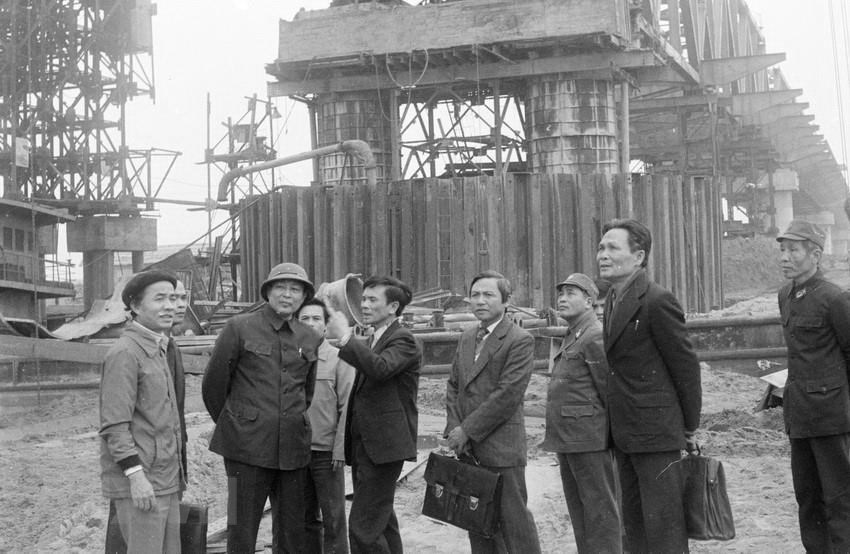  Đồng ch&iacute; Đồng Sỹ Nguy&ecirc;n, Ủy vi&ecirc;n dự khuyết Bộ Ch&iacute;nh trị, Ph&oacute; Chủ tịch Hội đồng Bộ trưởng, Bộ trưởng Bộ Giao th&ocirc;ng vận tải thăm c&aacute;n bộ, c&ocirc;ng nh&acirc;n Đội 162, X&iacute; nghiệp cầu 16 đang thi c&ocirc;ng x&acirc;y dựng cầu Chương Dương, ng&agrave;y 15/2/1985. (Ảnh: Quang Triệu/TTXVN)