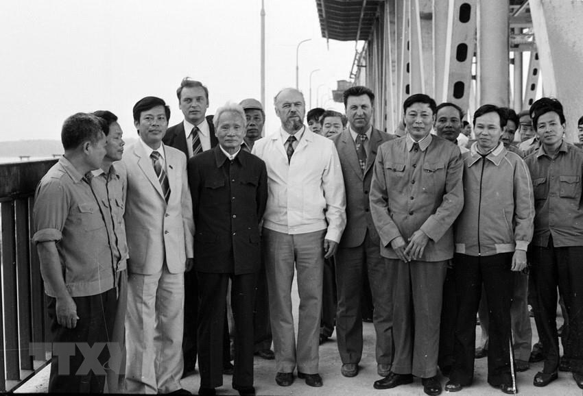  Bộ trưởng Bộ Giao th&ocirc;ng vận tải Đồng Sỹ Nguy&ecirc;n (thứ ba từ phải sang) c&ugrave;ng c&aacute;c chuy&ecirc;n gia Li&ecirc;n X&ocirc; v&agrave; c&ocirc;ng nh&acirc;n Việt Nam đ&oacute;n Chủ tịch Hội đồng Bộ trưởng Phạm Văn Đồng đến thăm c&ocirc;ng trường x&acirc;y dựng cầu Thăng Long, ng&agrave;y 5/11/1983. (Ảnh: Xu&acirc;n L&acirc;m/TTXVN)