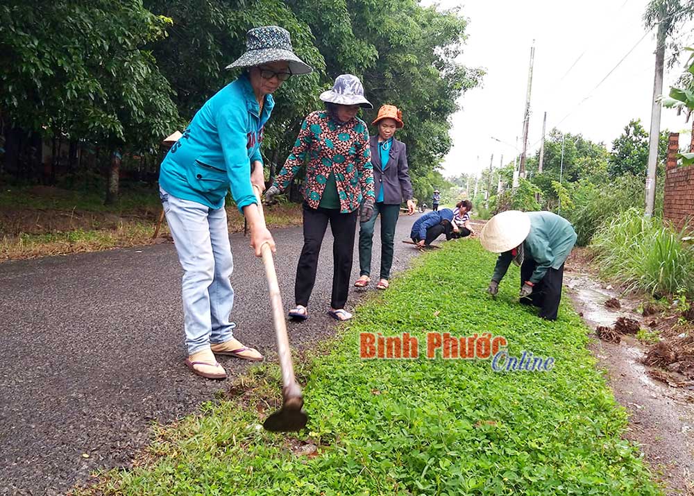 Hội viên phụ nữ ấp 7, xã Tiến Hưng (Đồng Xoài) dọn vệ sinh các tuyến đường trong khu dân cư