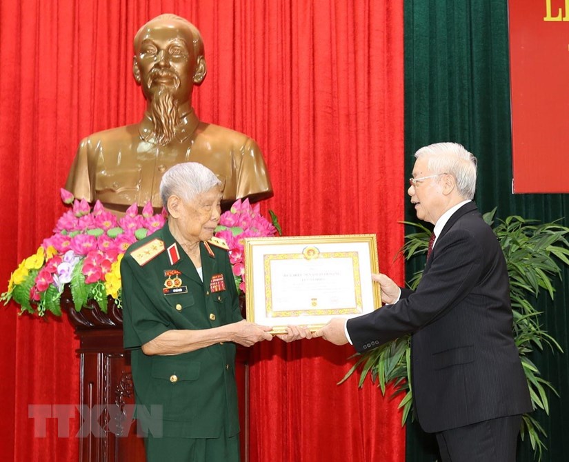 Tổng Bí thư, Chủ tịch nước Nguyễn Phú Trọng, Bí thư Quân ủy Trung ương trao Huy hiệu 70 năm tuổi Đảng tặng đồng chí Lê Khả Phiêu. (Ảnh: Trí Dũng/TTXVN)