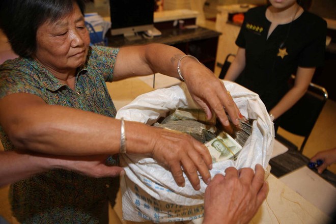 Cặp vợ chồng già vác cả bao tải tiền lẻ để đi mua nhà