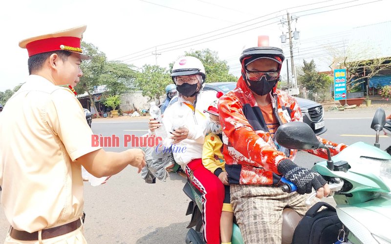 Cảnh sát giao thông Bình Phước tặng nước và khăn lạnh cho người dân về quê nghỉ lễ