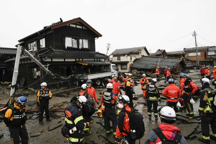 Cảnh sát và lính cứu hỏa tìm kiếm người mắc kẹt trong đống đổ nát của những ngôi nhà bị sập sau động đất tại tỉnh Ishikawa, Nhật Bản ngày 3/1/2024. (Ảnh: Kyodo/TTXVN) 