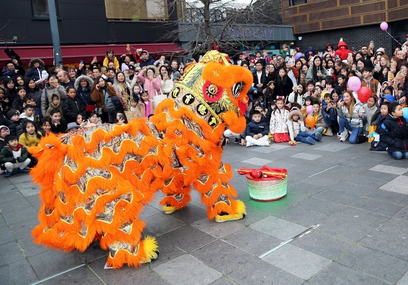 Kiều bào và người dân sở tại xem biểu diễn múa lân tại lễ hội. (Ảnh: Phong Hà/TTXVN)