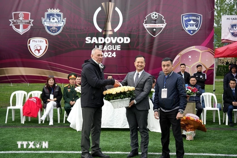 Tham tán Vũ Sơn Việt, Phó Trưởng ban công tác cộng đồng Đại sứ quán Việt Nam tại Nga (giữa) tặng hoa Ban tổ chức Sadovod League 2024. (Ảnh: Quang Vinh/TTXVN)