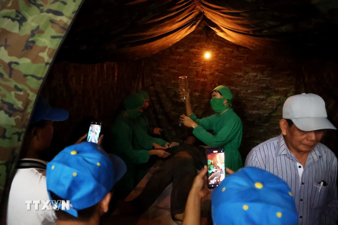 Khách tham quan phòng cứu thương ở địa đạo Củ Chi. (Ảnh: Hồng Đạt/TTXVN) ttxvn-0205-cu-chi-2.jpg