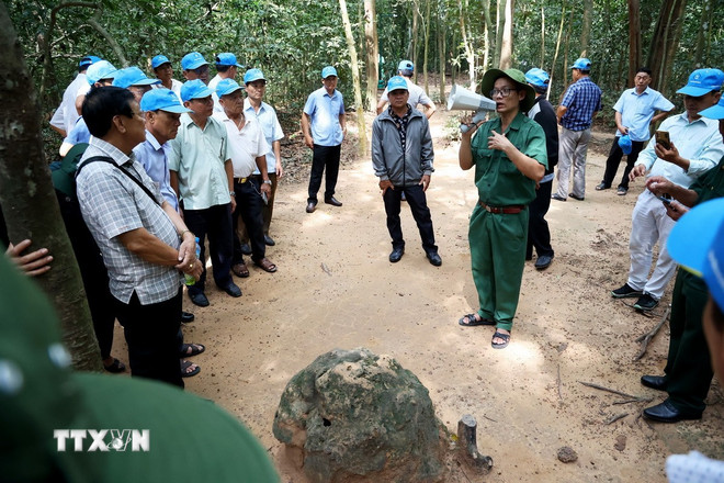 Khách tham quan tìm hiểu lỗ thông hơi địa đạo Củ Chi. (Ảnh: Hồng Đạt/TTXVN) ttxvn-0205-cu-chi-1.jpg