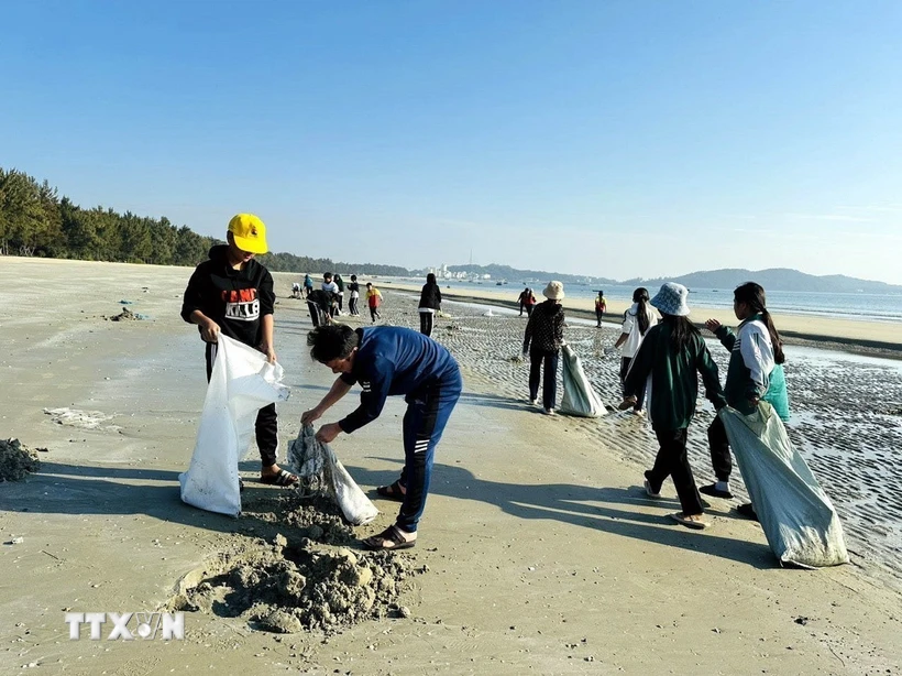 Học sinh trên đảo Cô Tô cùng tham gia thu gom rác thải, dọn sạch bãi biển. (Ảnh: TTXVN phát)