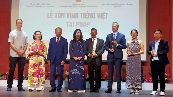 Thứ trưởng Ngoại giao Lê Thị Thu Hằng trao quà lưu niệm cho các đại diện hội đoàn người Việt Nam tại Pháp. (Ảnh: Nguyễn Tuyên/TTXVN) ton vinh tieng viet_paris 3.jpeg